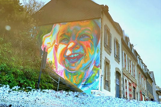 Fresque colorée représentant un enfant souriant, évoquant l’expression émotionnelle et le développement personnel