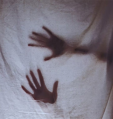 Silhouette derrière un voile symbolisant les blocages émotionnels et le travail thérapeutique intérieur