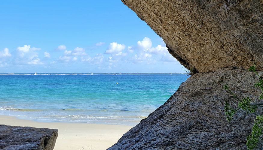 Vue sur la mer depuis une ouverture rocheuse évoquant l’apaisement et la prise de recul face au stress